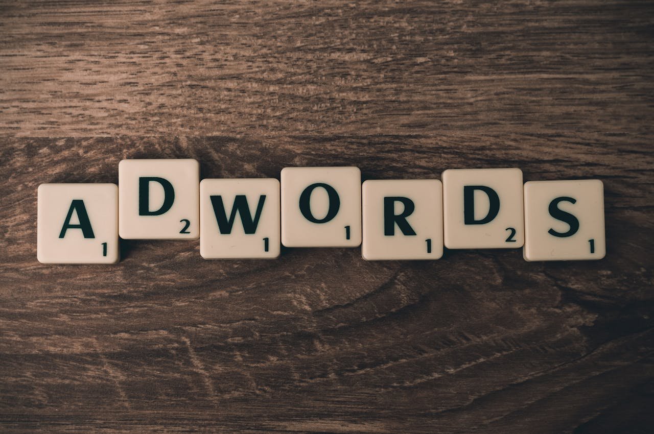 gallery-01 Scrabble tiles spelling 'AdWords' on a wooden surface, symbolizing digital marketing concepts.